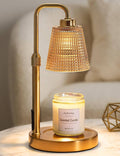 Gold candle warmer lamp with amber glass shade and scented jar candle on base