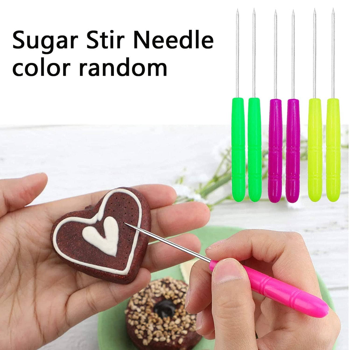 Sugar stir needle for decorating with colored handles, holding a cookie