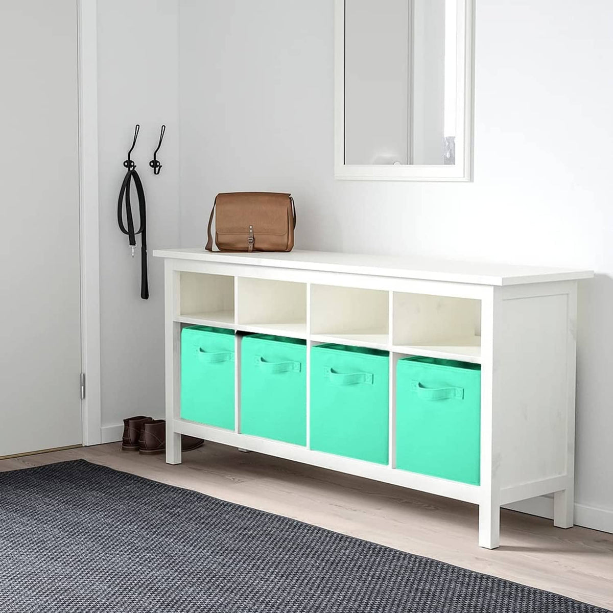 Mint green fabric storage cube bins with front handles, arranged in a cabinet row