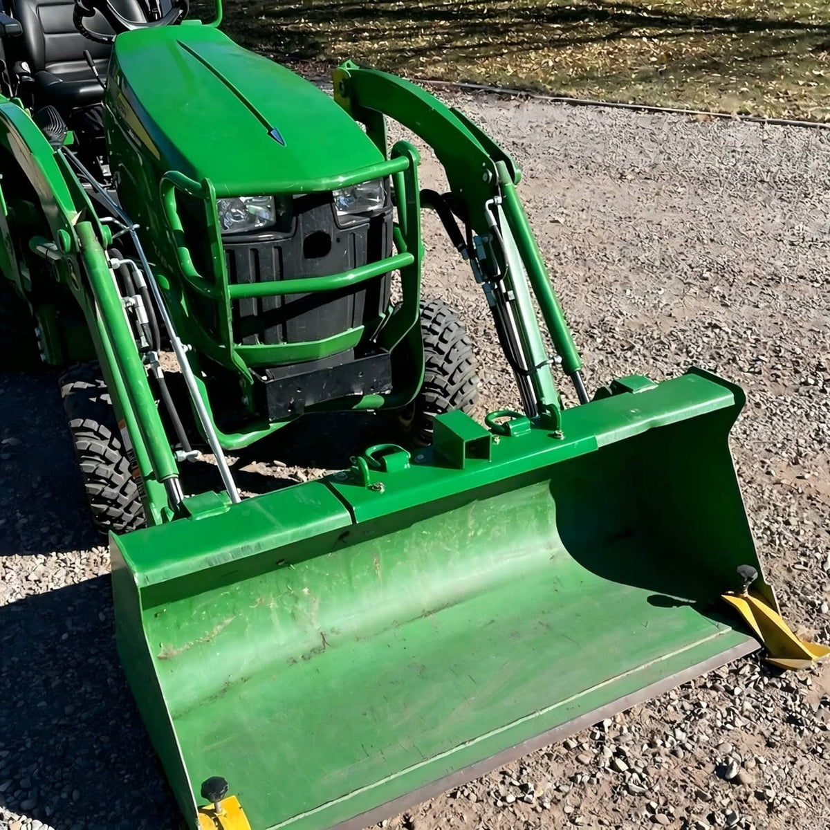 Green receiver D-ring grab hook bracket installed on a tractor front attachment