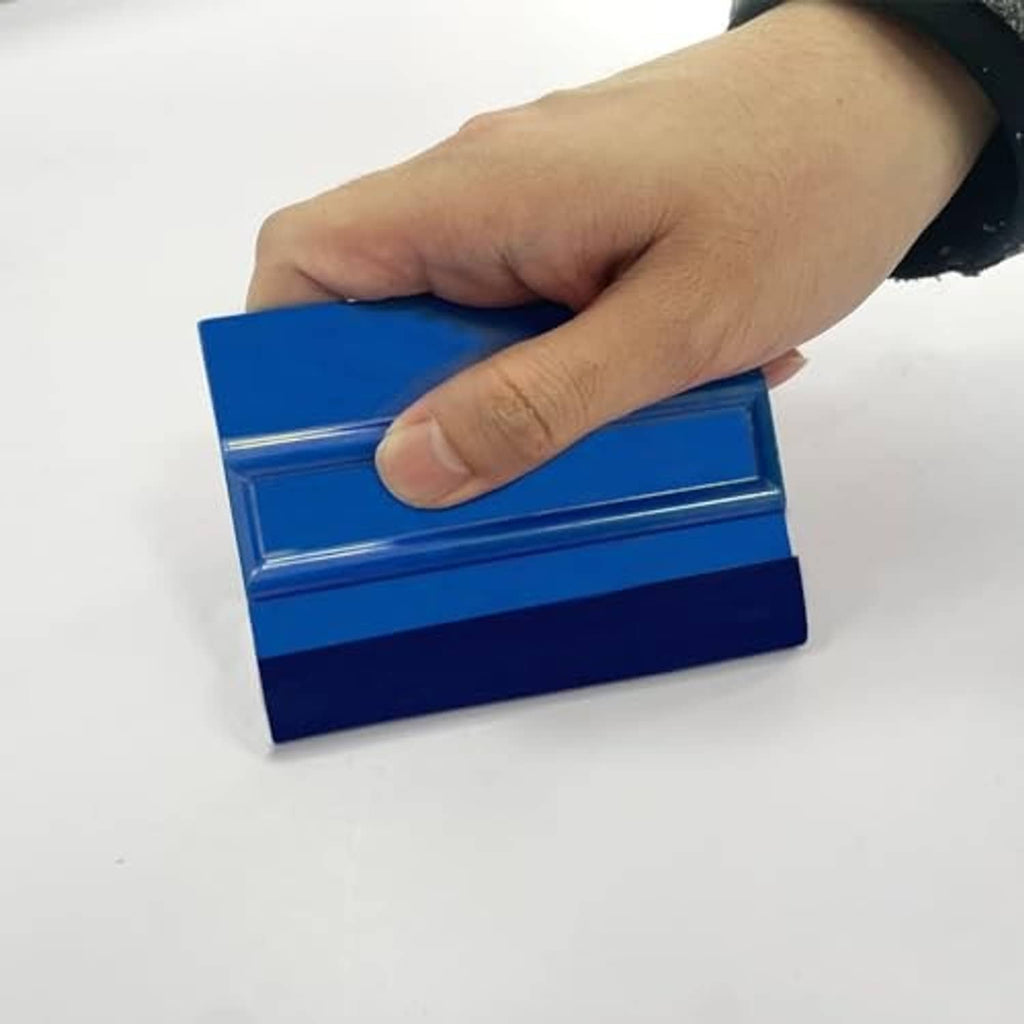 Blue felt vinyl squeegee with ribbed edge, held in hand for smoothing