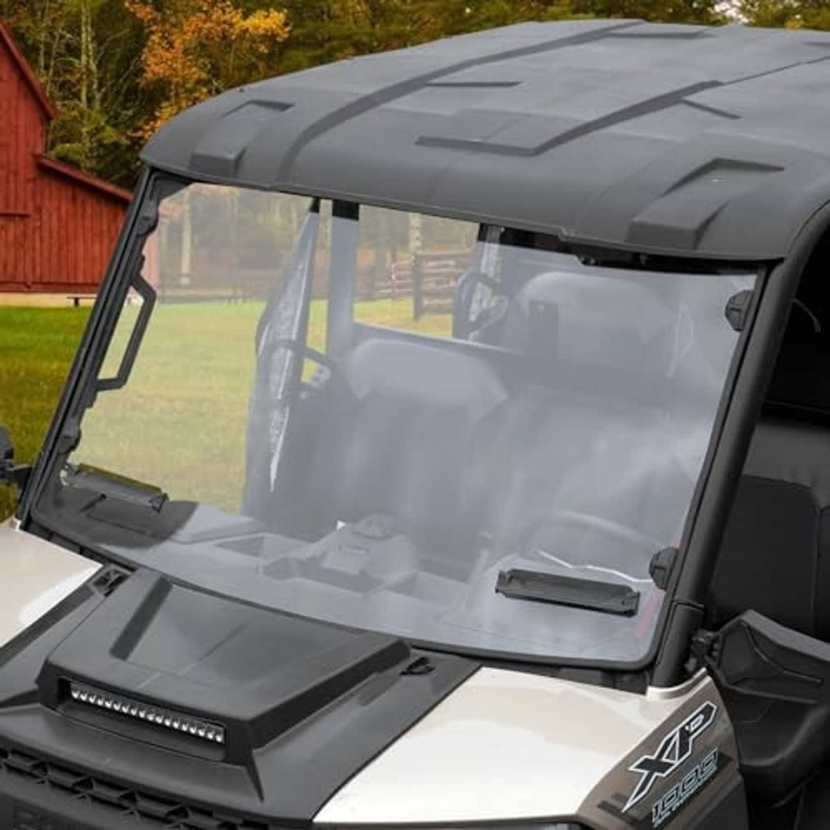 Front UTV windshield with dark frame and clear tinted panel, side view on vehicle