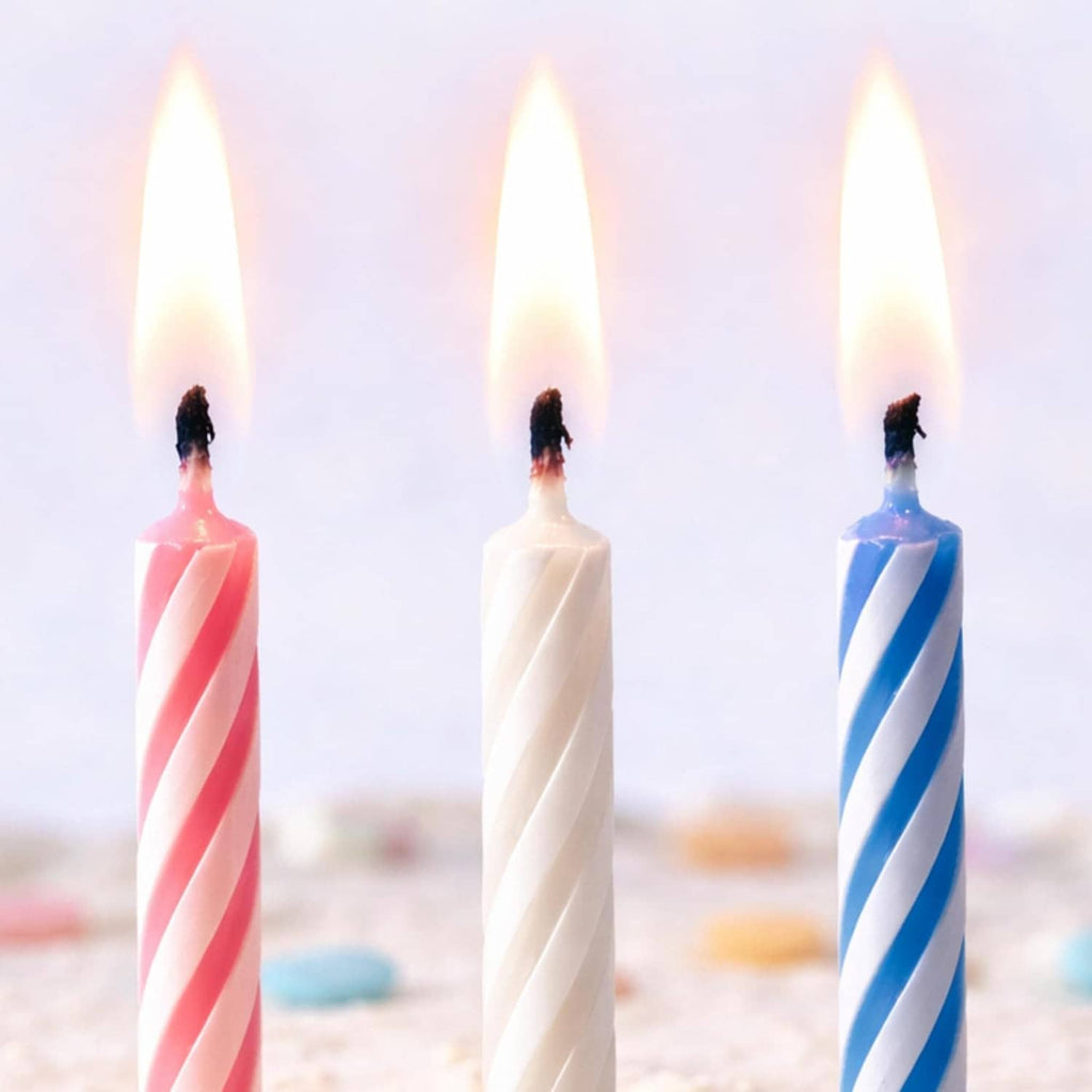 Three striped birthday candles: red, white, and blue with wick tips