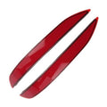 Two red rear bumper reflector lenses with black trim, curved oval shapes