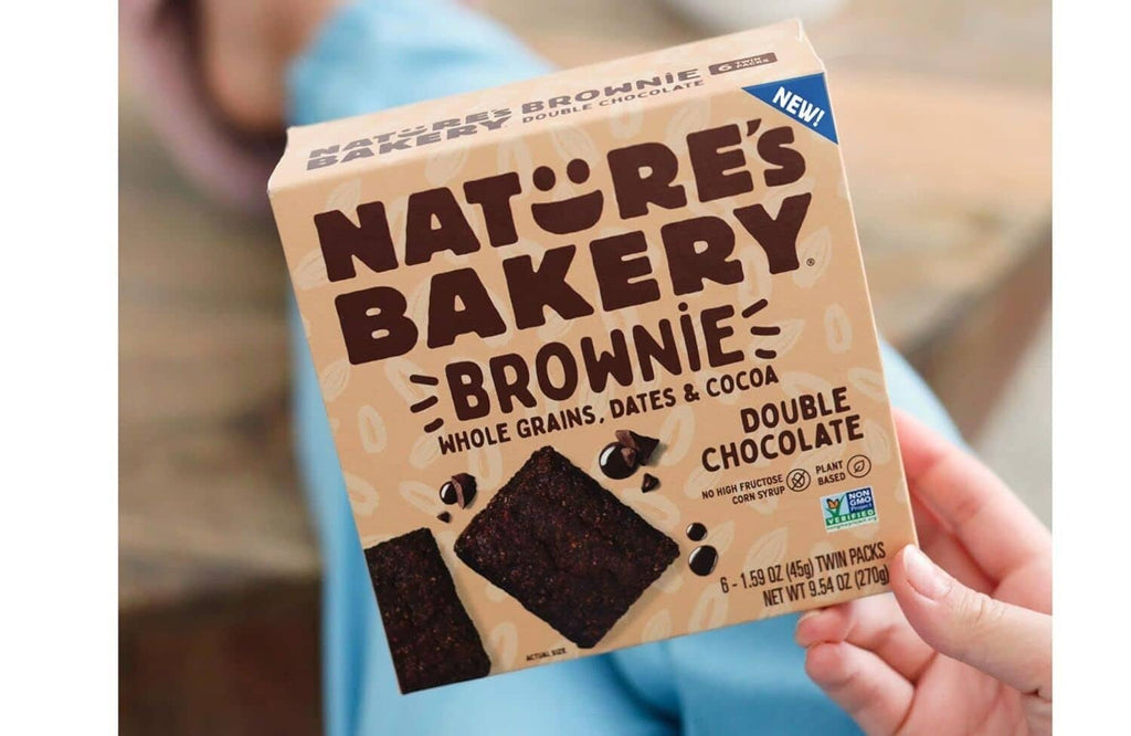 Hand holding Nature's Bakery double chocolate brownie bar package, plant based