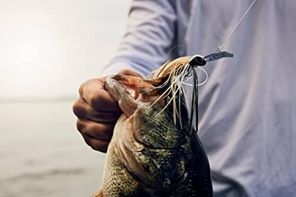Fishing bladed jig with black head, white fibers, and golden blade