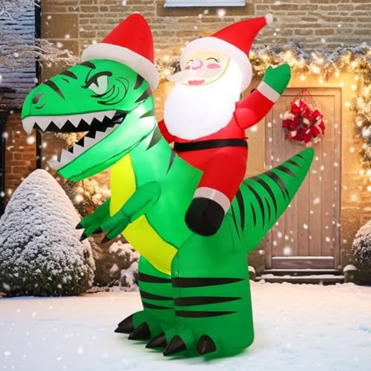 Inflatable Santa riding green crocodile on snowy ground in front of house door