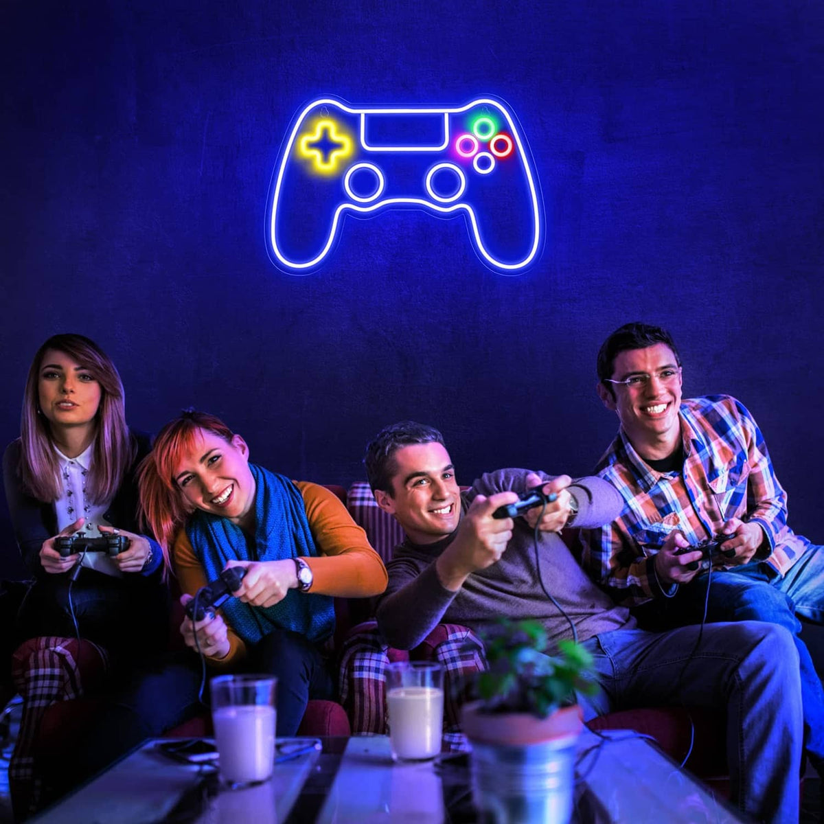 Gaming controller LED neon sign glowing above friends playing video games at a table.