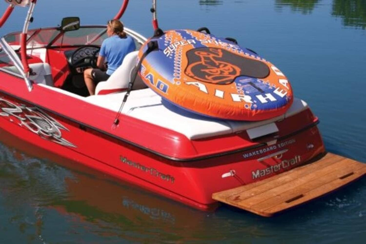 Inflatable tow tube with securing straps and metal loops on boat deck