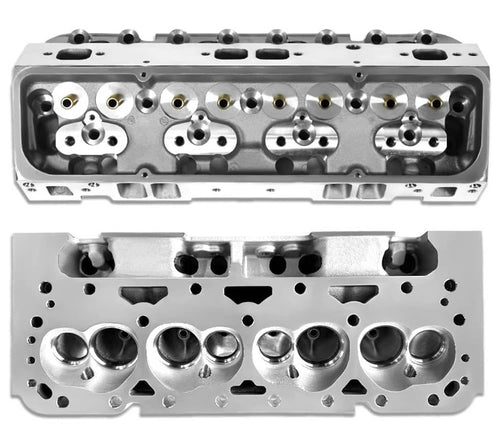 Pair of bare cylinder heads with exposed valve ports and bolt holes, silver metal finish