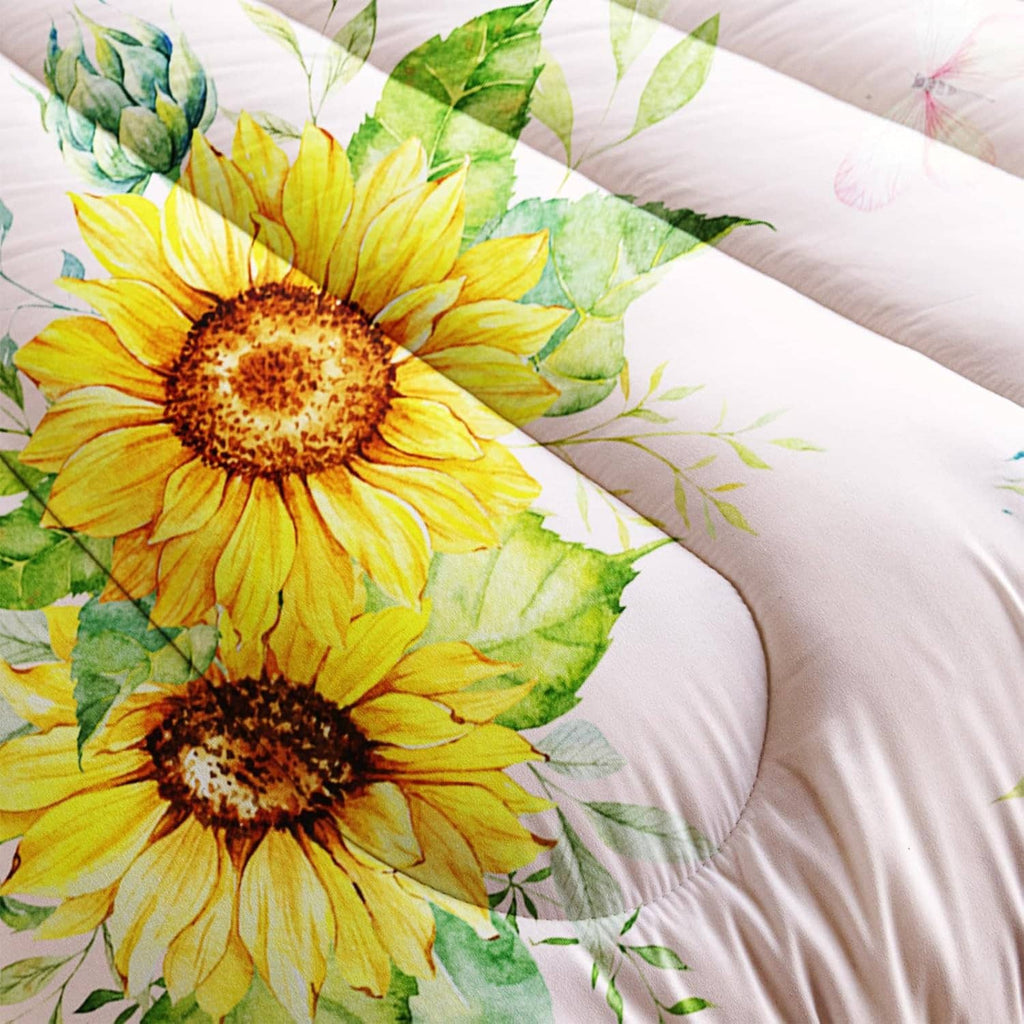 Pink comforter close-up with yellow sunflower blooms and leaf accents