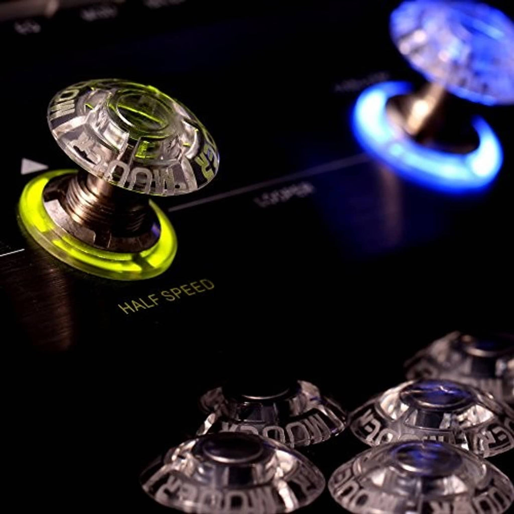 Close-up of clear mushroom-shaped pedal footswitch toppers with metal stems