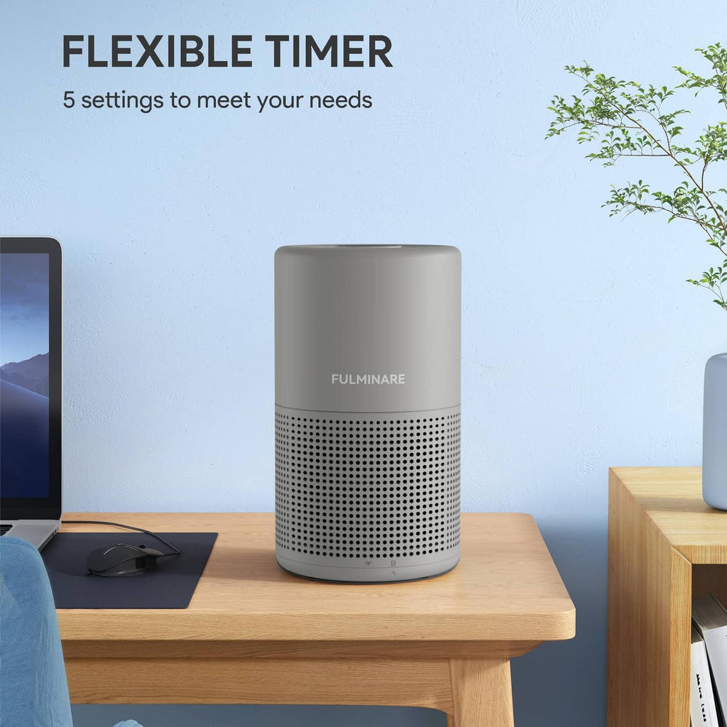 Gray FULMINARE air purifier on a wooden console, cylindrical with front grille