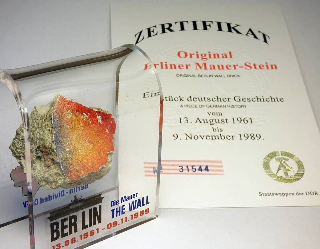 Acrylic display case with rough Berlin Wall rock and certificate card, mounted behind glass
