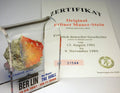 Acrylic display case with rough Berlin Wall rock and certificate card, mounted behind glass