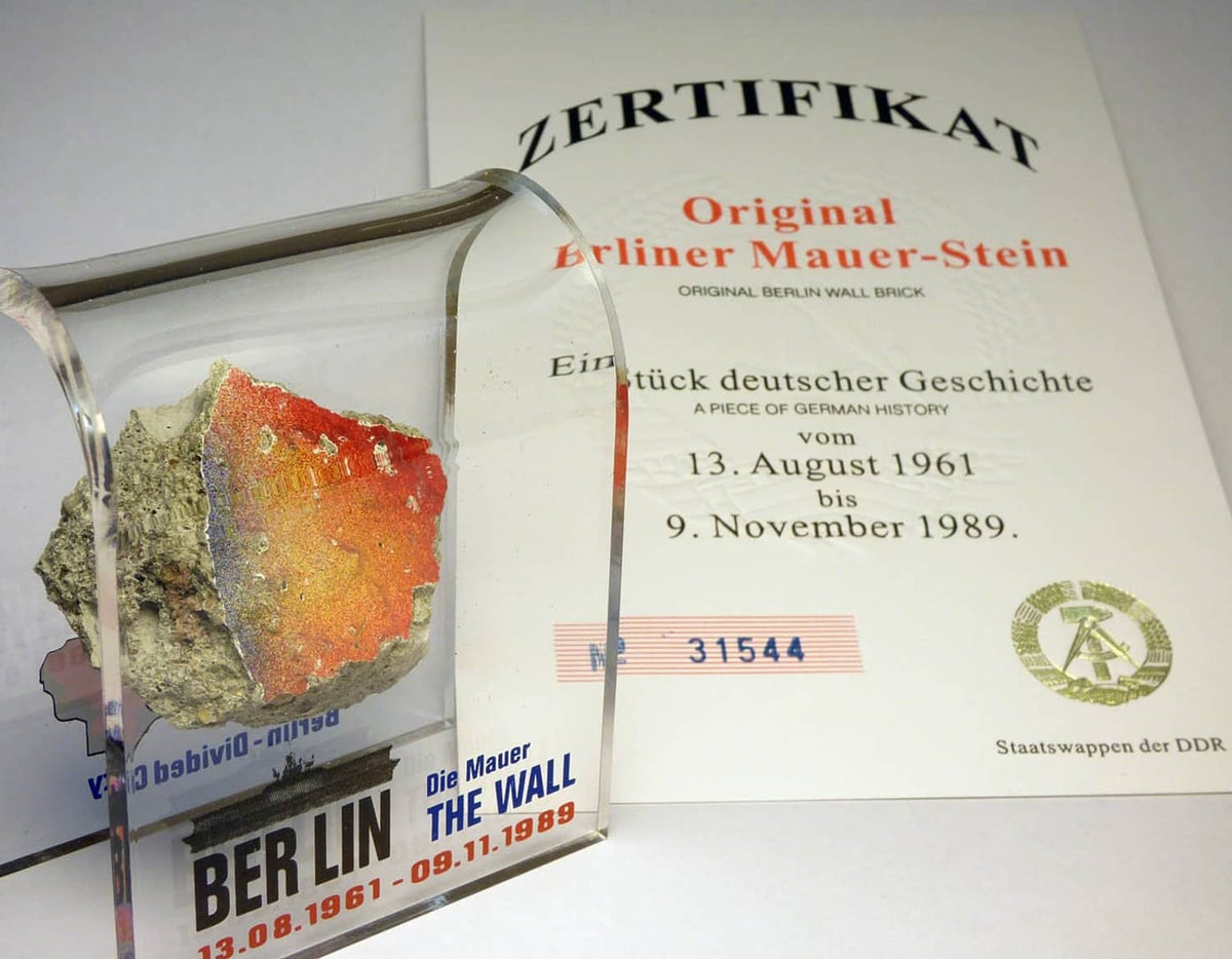 Acrylic display case with rough Berlin Wall rock and certificate card, mounted behind glass