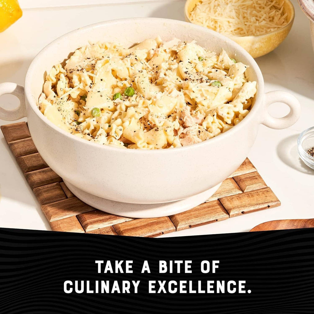 Albacore tuna casserole in white bowl with shredded cheese and herbs