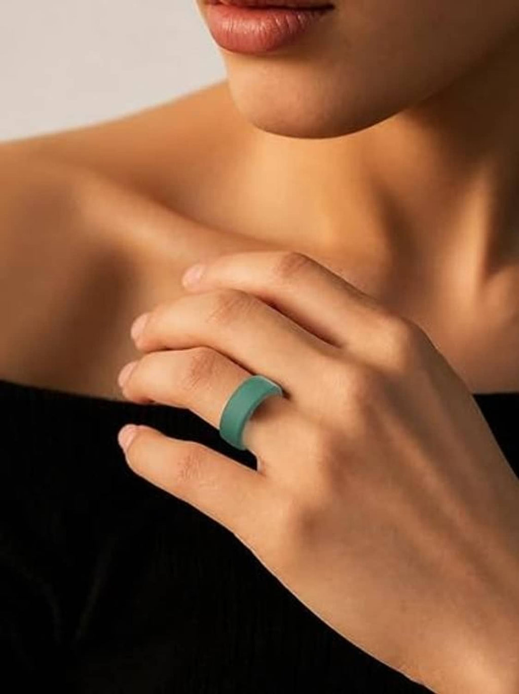 Dark green silicone ring cover worn on finger, showing sensor and light window