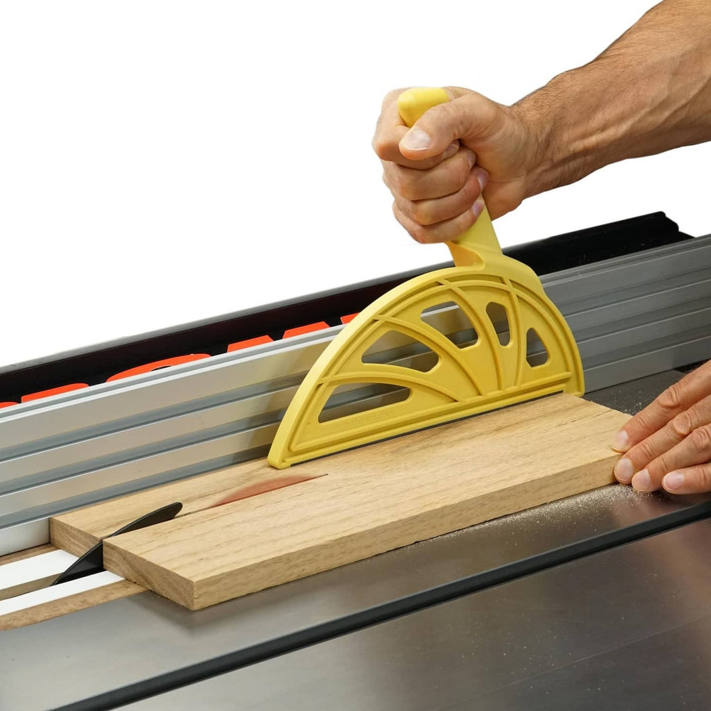 Yellow push block with ergonomic handle for guiding wood on table saw rails