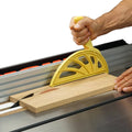 Yellow push block with ergonomic handle for guiding wood on table saw rails