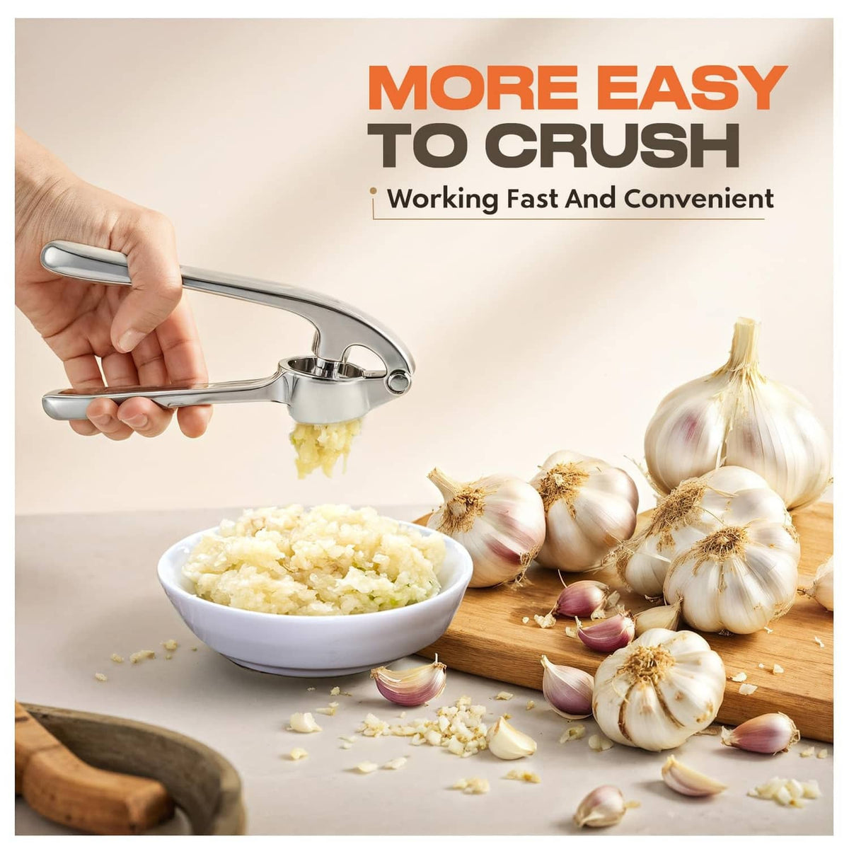 Stainless steel garlic press being squeezed by hand above a bowl of minced garlic