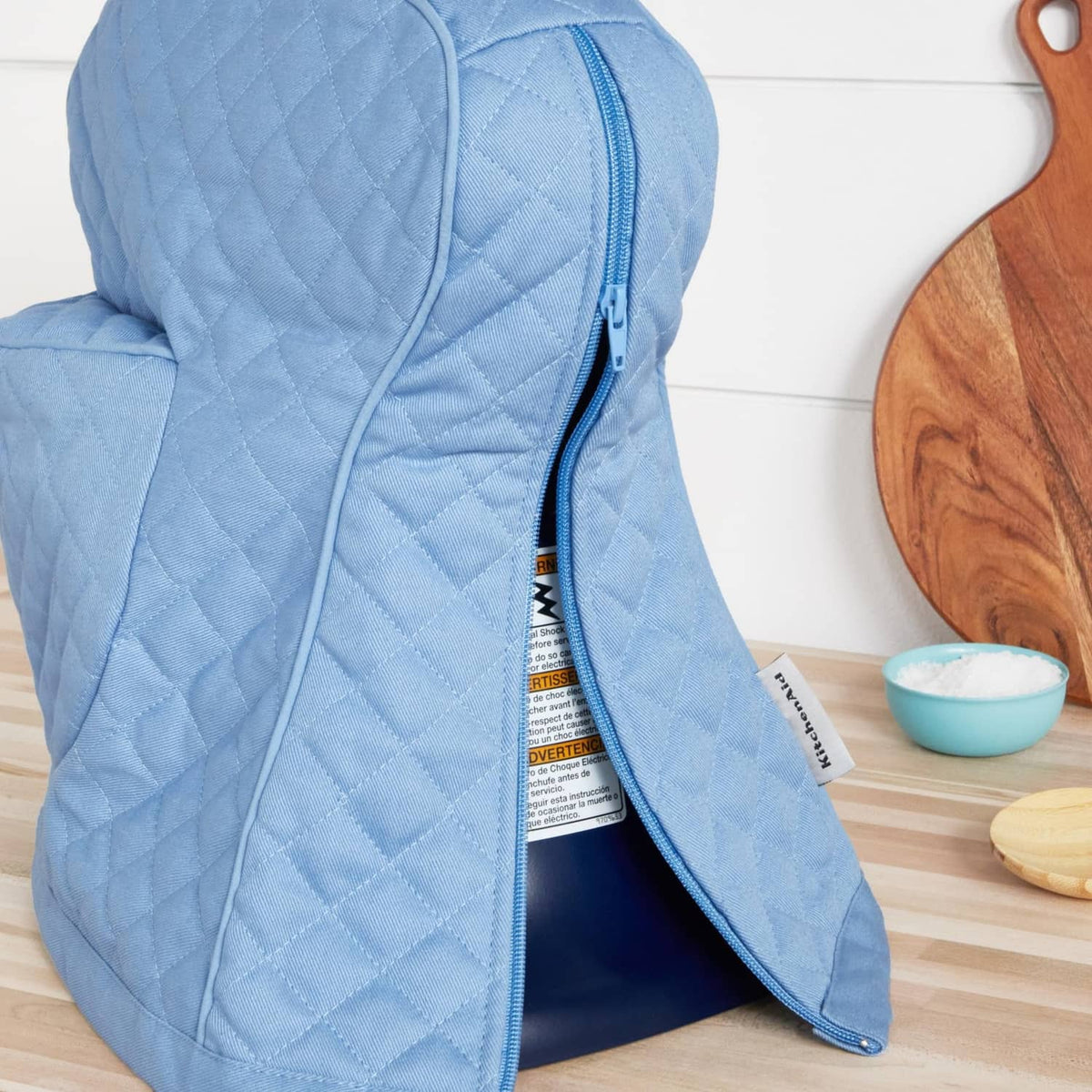 Blue quilted stand mixer cover with long zipper and opening to insert mixer