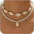 Handmade shell necklace with white bead strands and cowrie shells, gold-tone accents