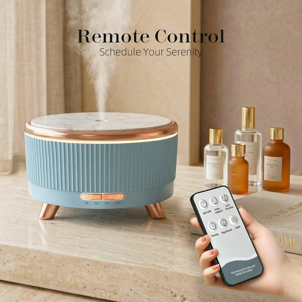 Blue ultrasonic essential oil diffuser with copper feet, remote control visible in foreground.