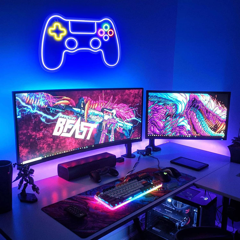 Game controller LED neon sign glowing blue above a gaming desk and monitors.
