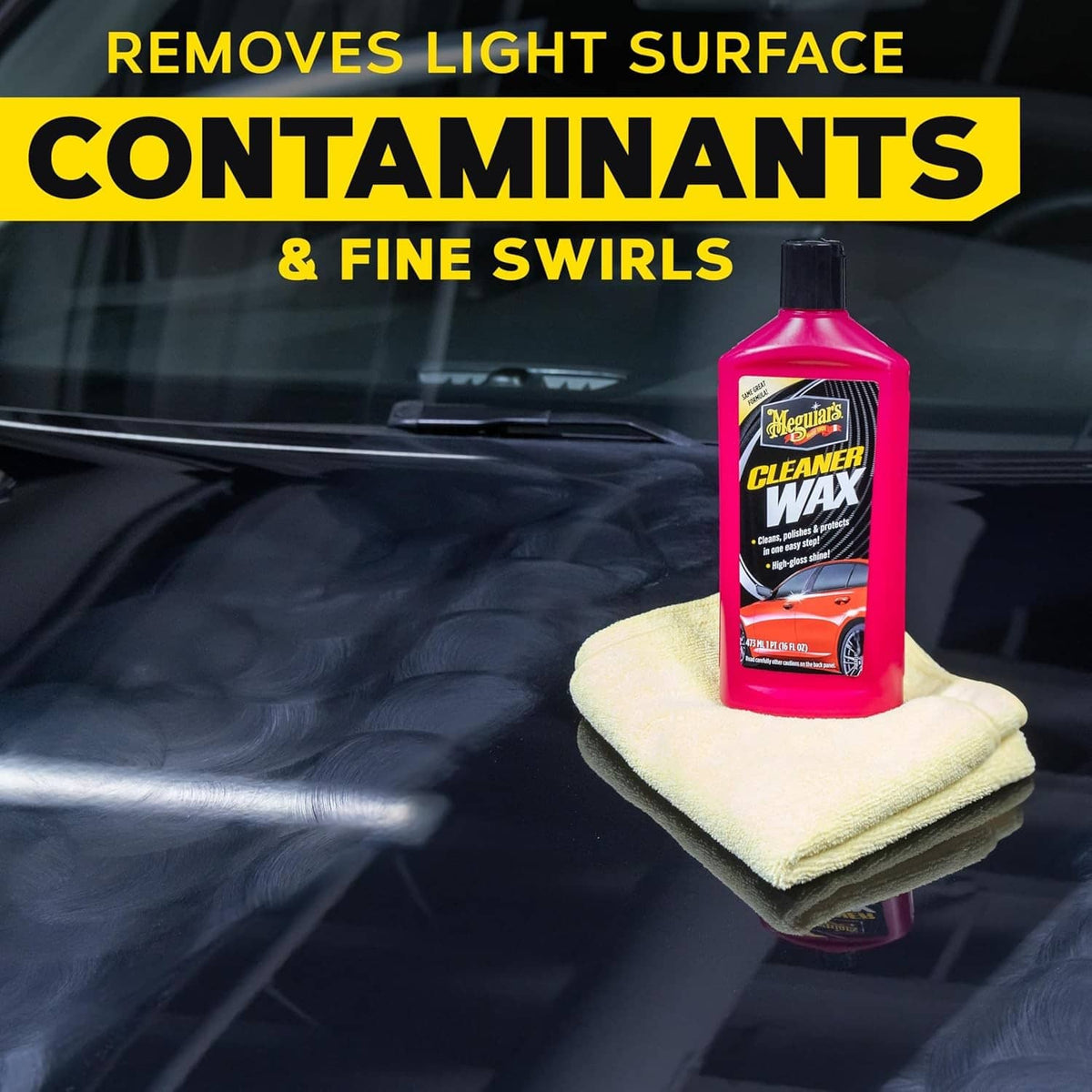 Red cleaner wax bottle held with a light cloth pad on a dark car surface