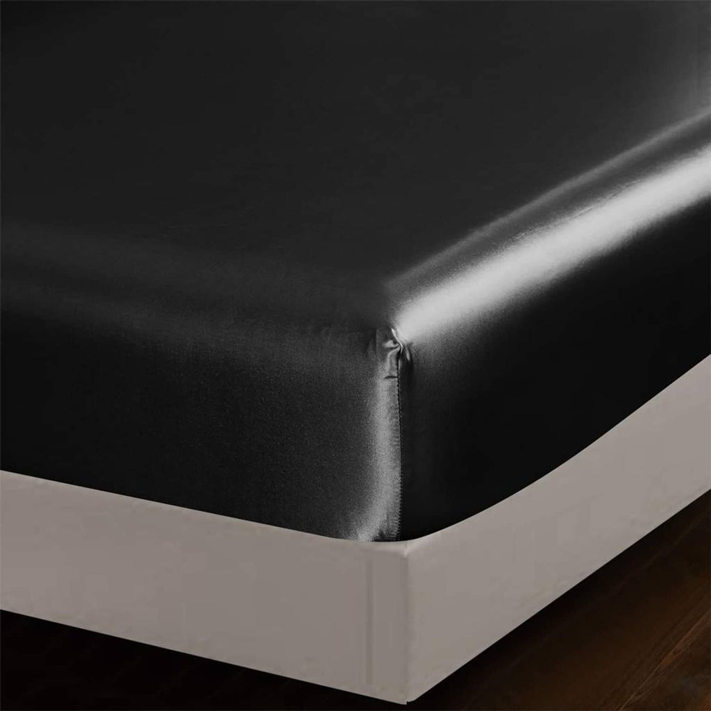 Black satin fitted sheet corner with smooth elasticized edge on a queen bed