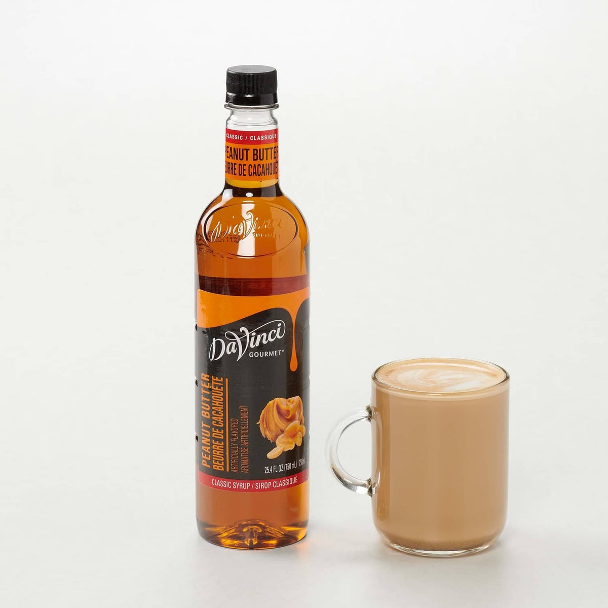 Peanut butter syrup bottle with mug filled creamy drink, side-by-side