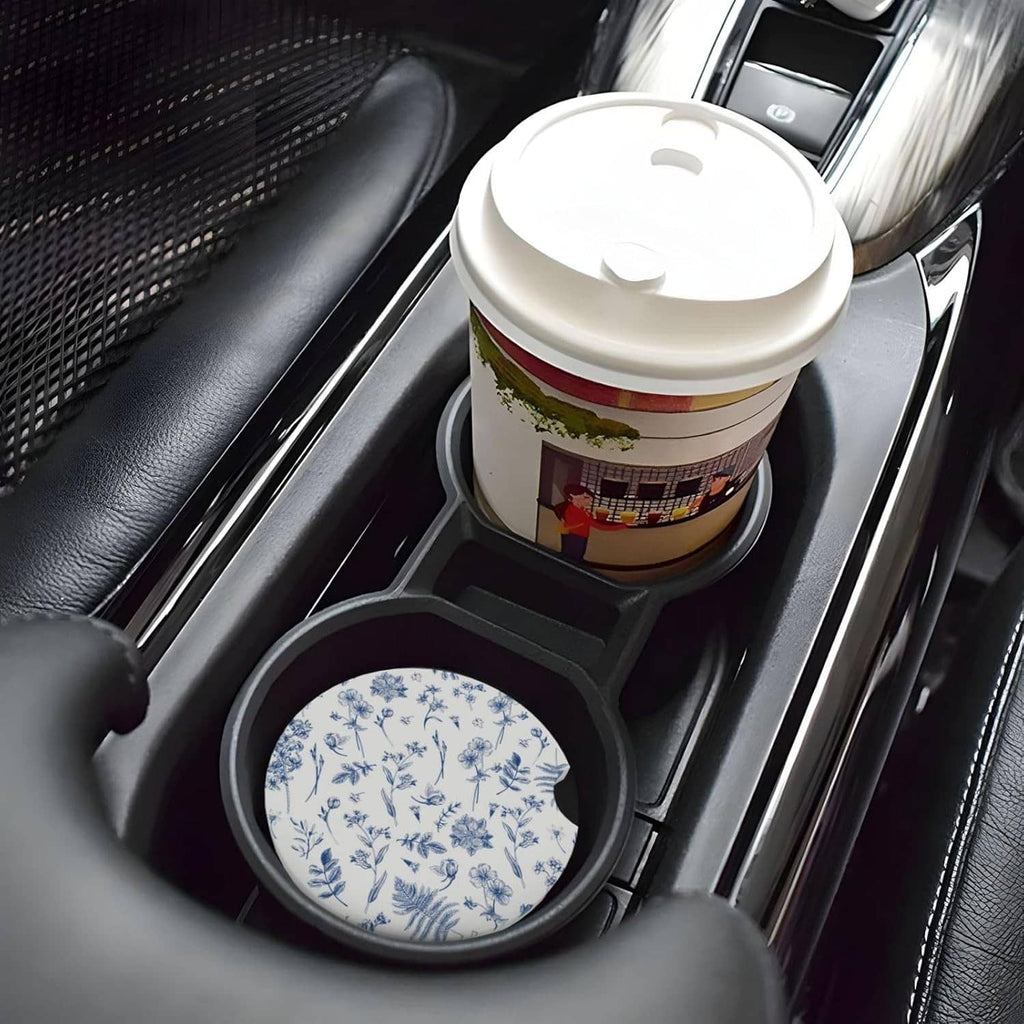 Blue floral ceramic car cup coaster sitting in a car cup holder