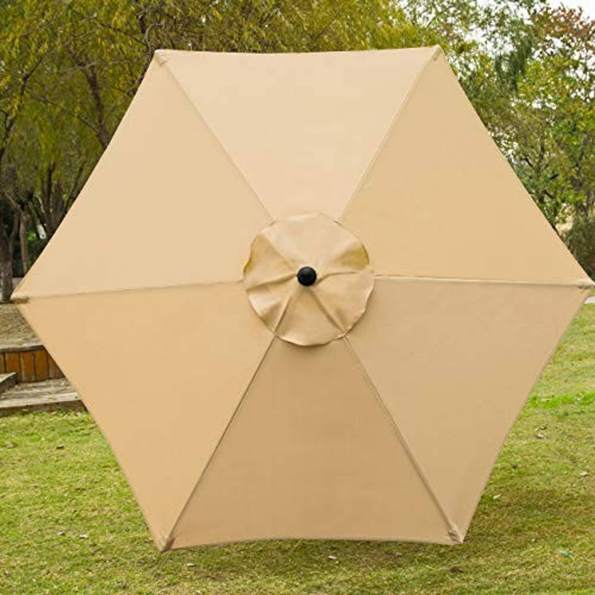 Tan outdoor patio umbrella fully open with circular top vent and black pole