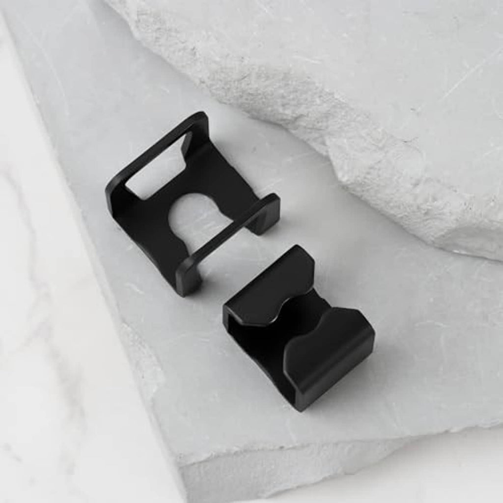 Black hydraulic floor jack spare part clips, two-piece set on tray.