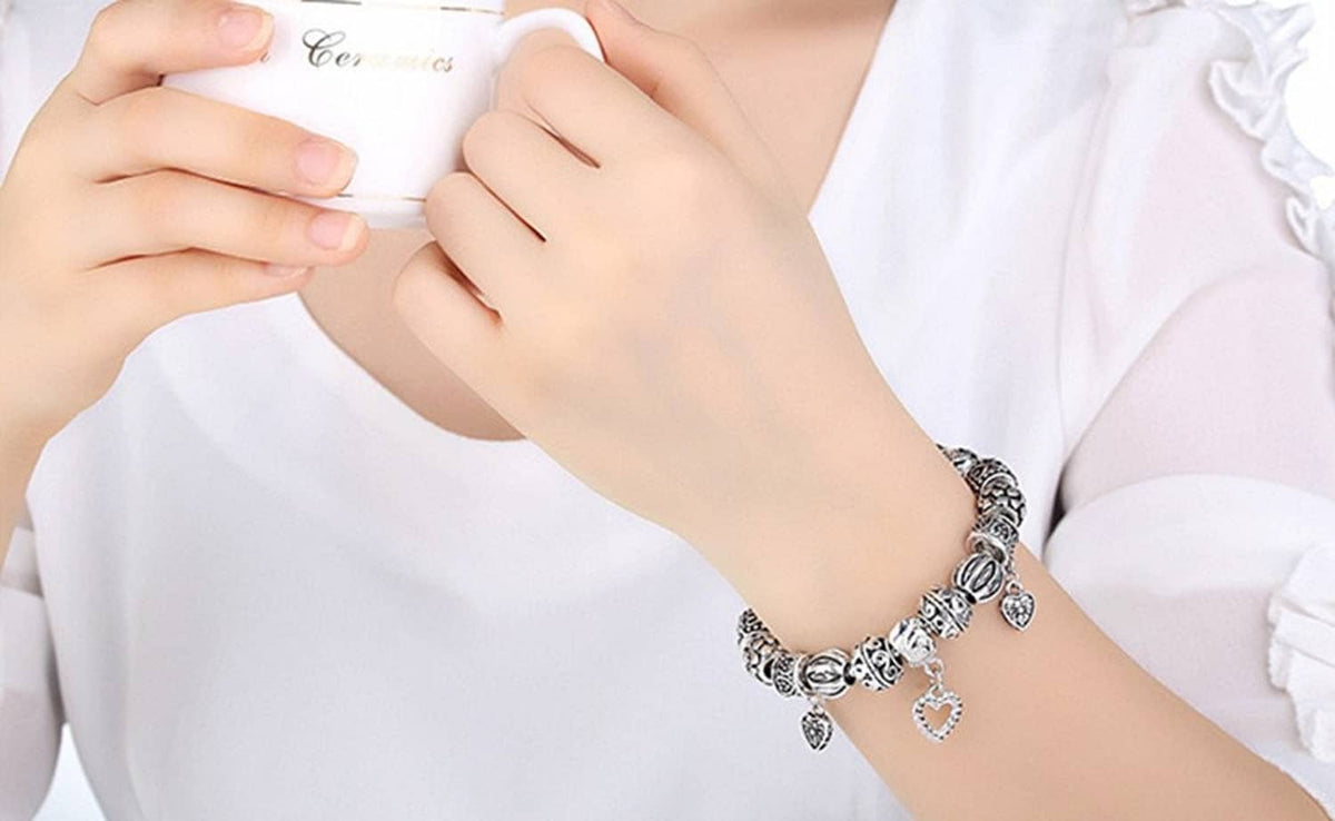 Silver heart bail charm connector bracelet, hands holding beaded necklace