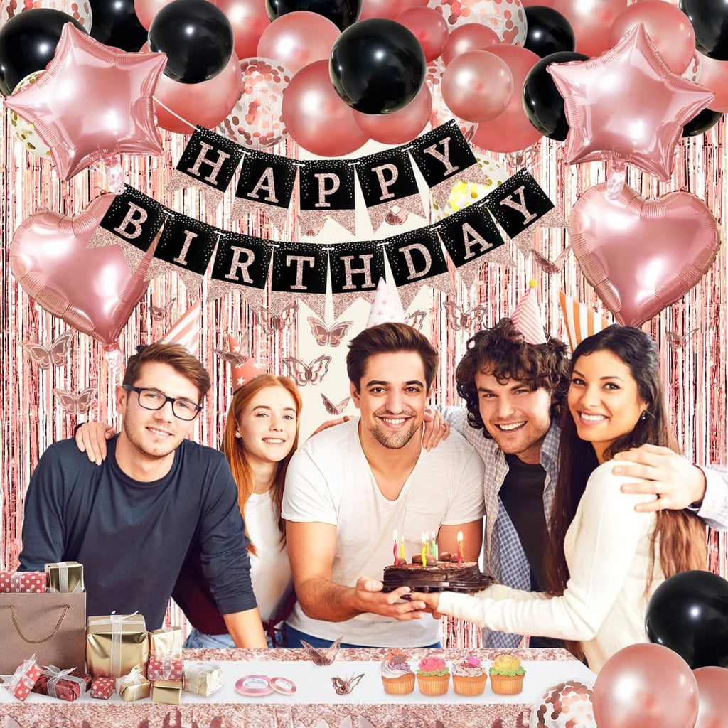 Happy Birthday banner with rose gold and black balloons over a decorated party table