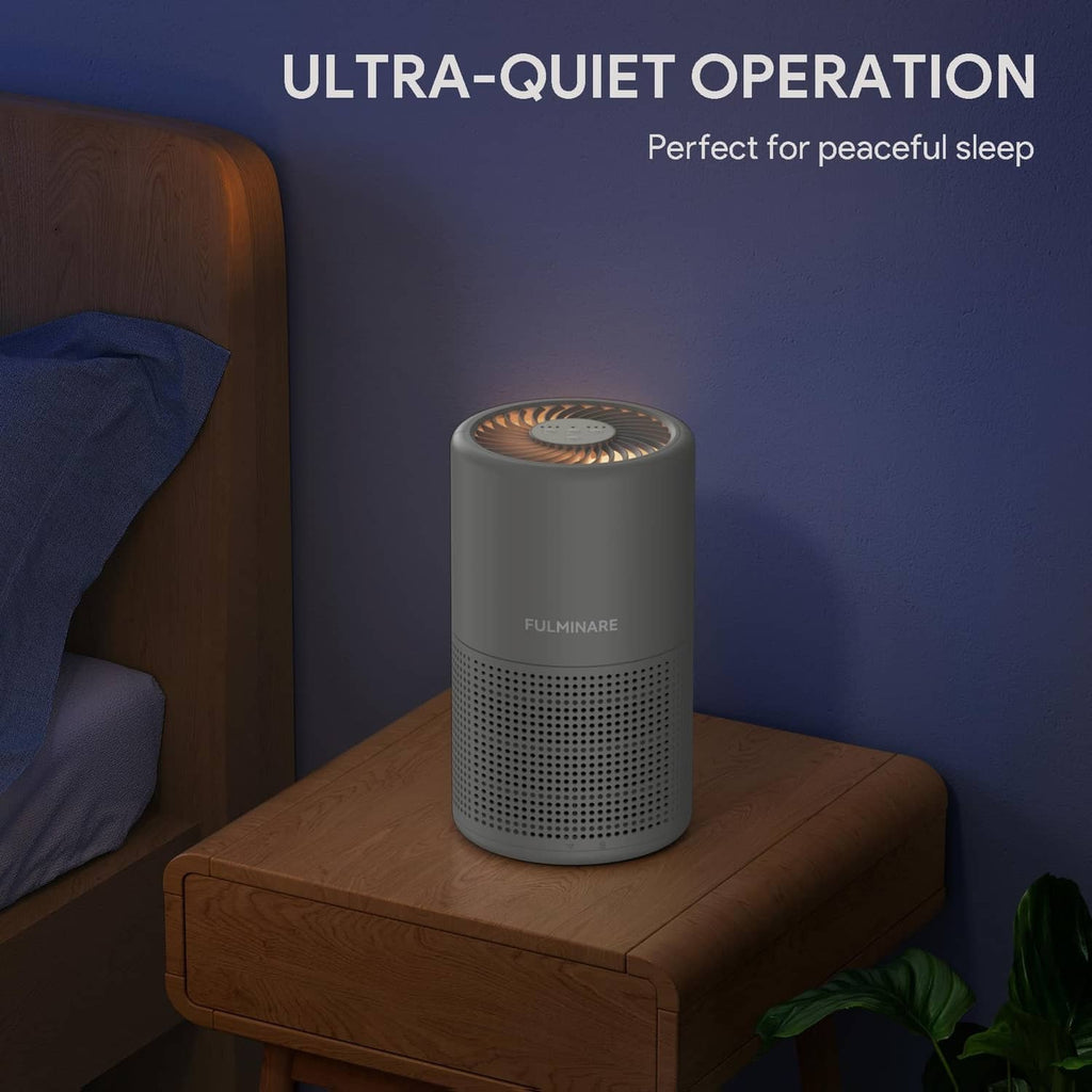Gray FULMINARE ultra-quiet air purifier on bedside table, cylindrical with front grille
