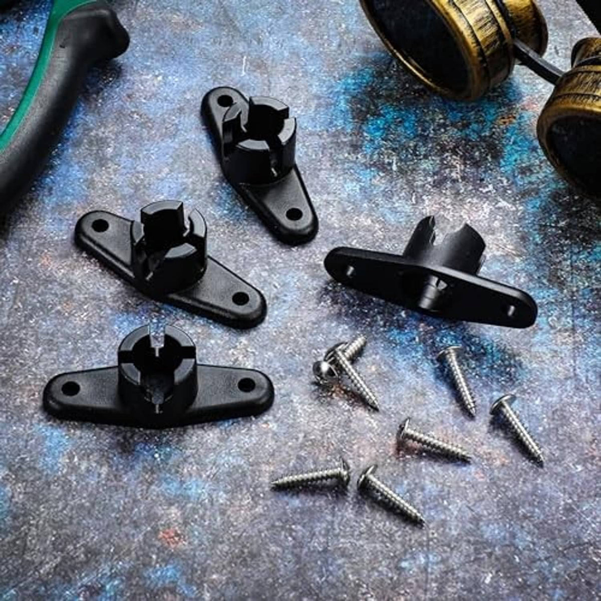 Black awning ball-end base brackets with screws laid out on a surface