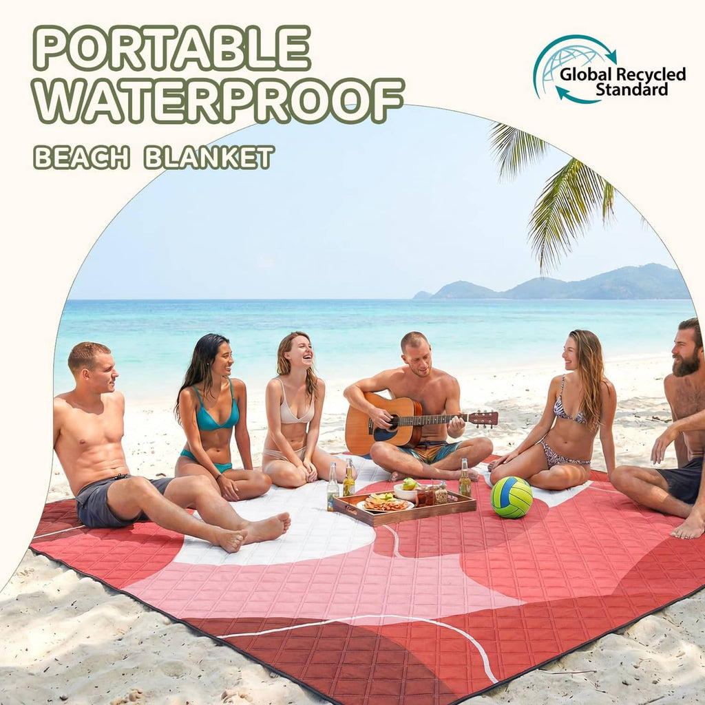 Red waterproof beach blanket with white wave-edged border spread on sand.