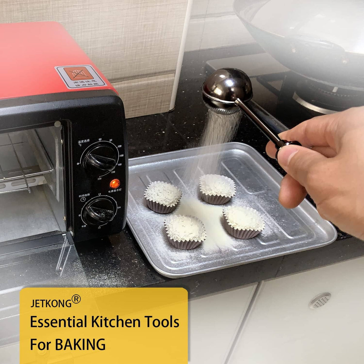 Black powdered sugar shaker duster sprinkling over cupcakes in foil liners