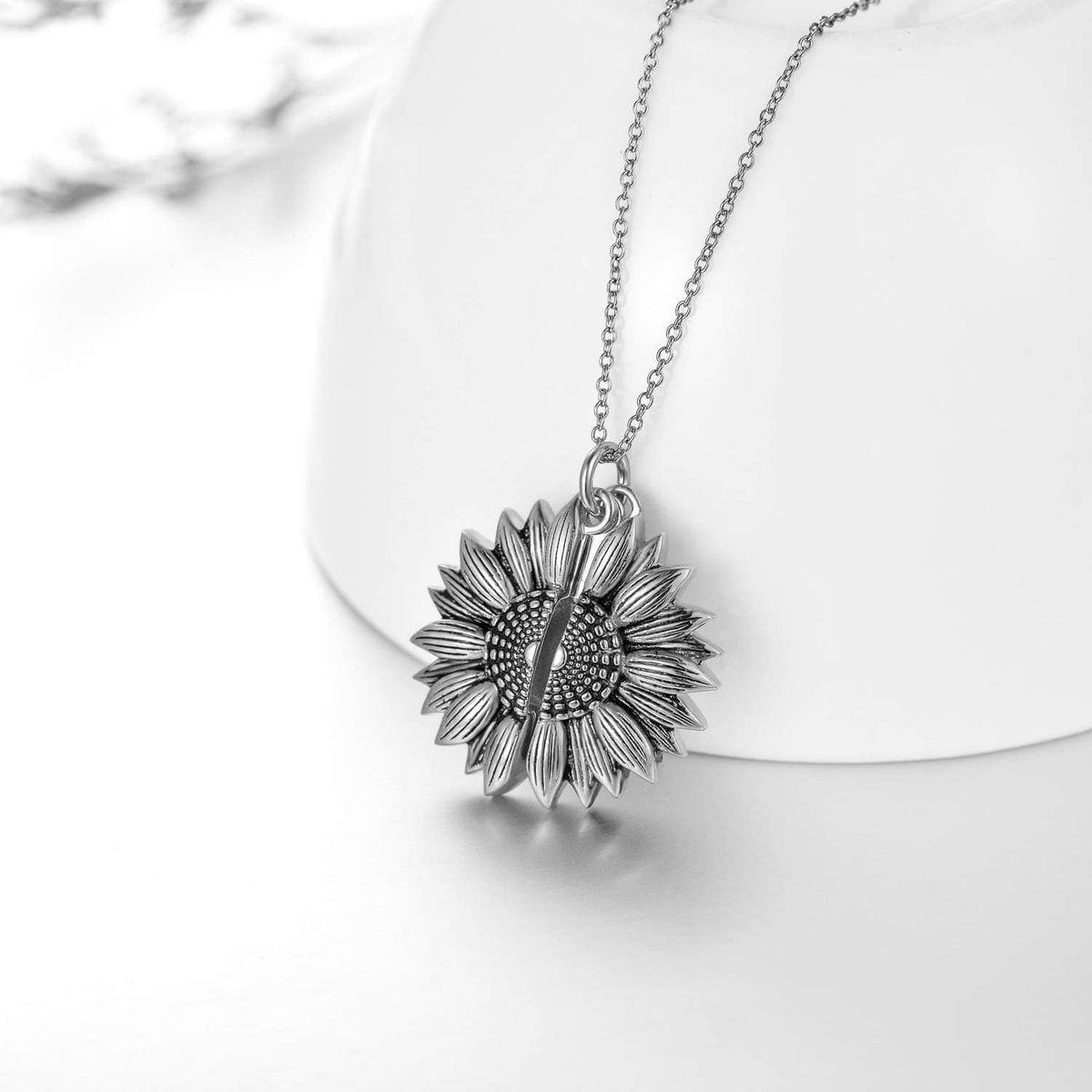 Sterling silver sunflower locket pendant necklace with engraved front, shown from the side