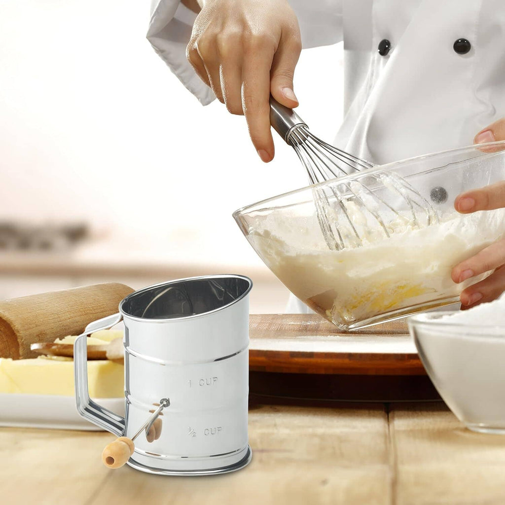 Stainless steel sifter dispensing powder into a mixing bowl