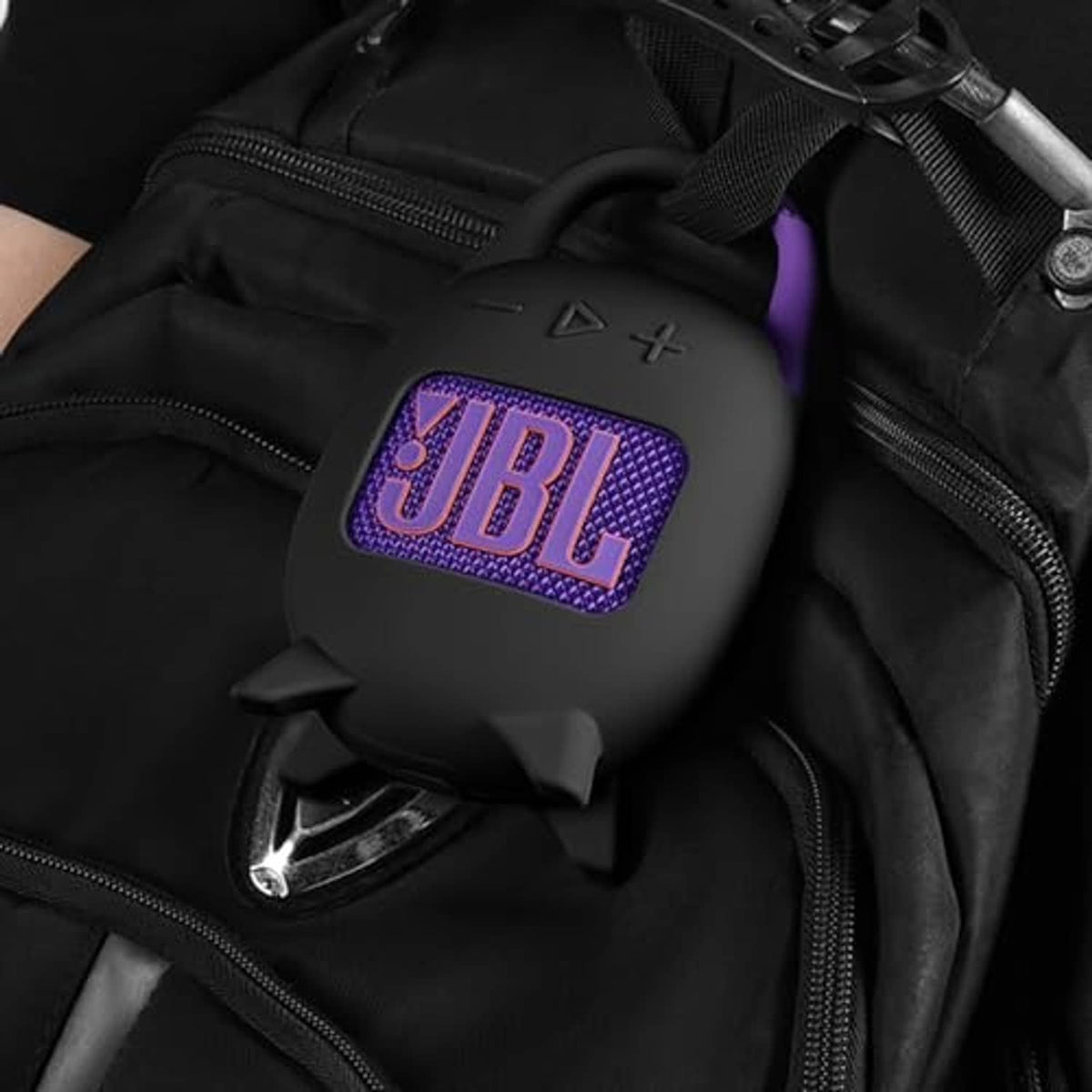 Black silicone carrying case inside a bag, purple JBL logo on front