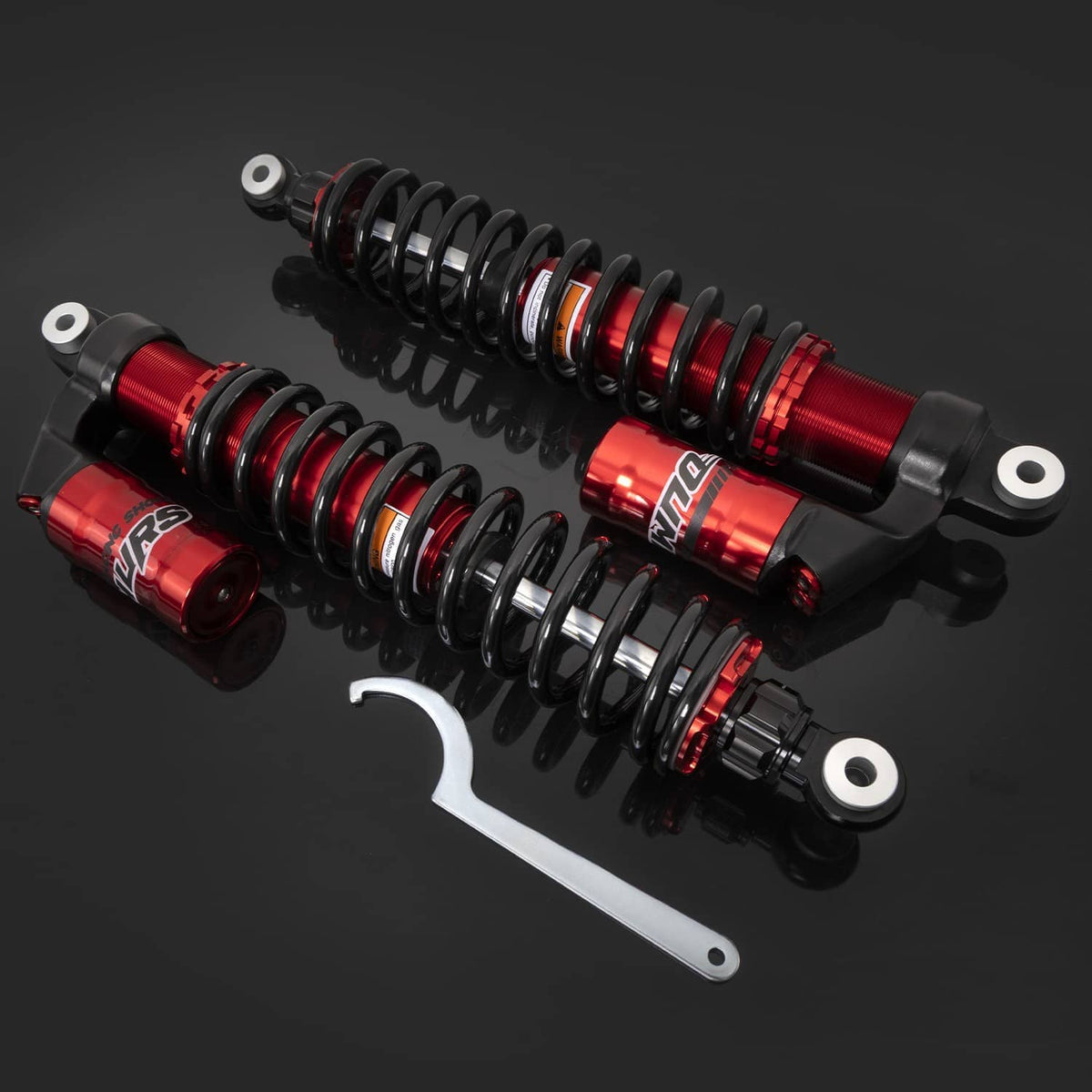 Red and black adjustable rear air shock absorbers with coil springs and silver mounting tool