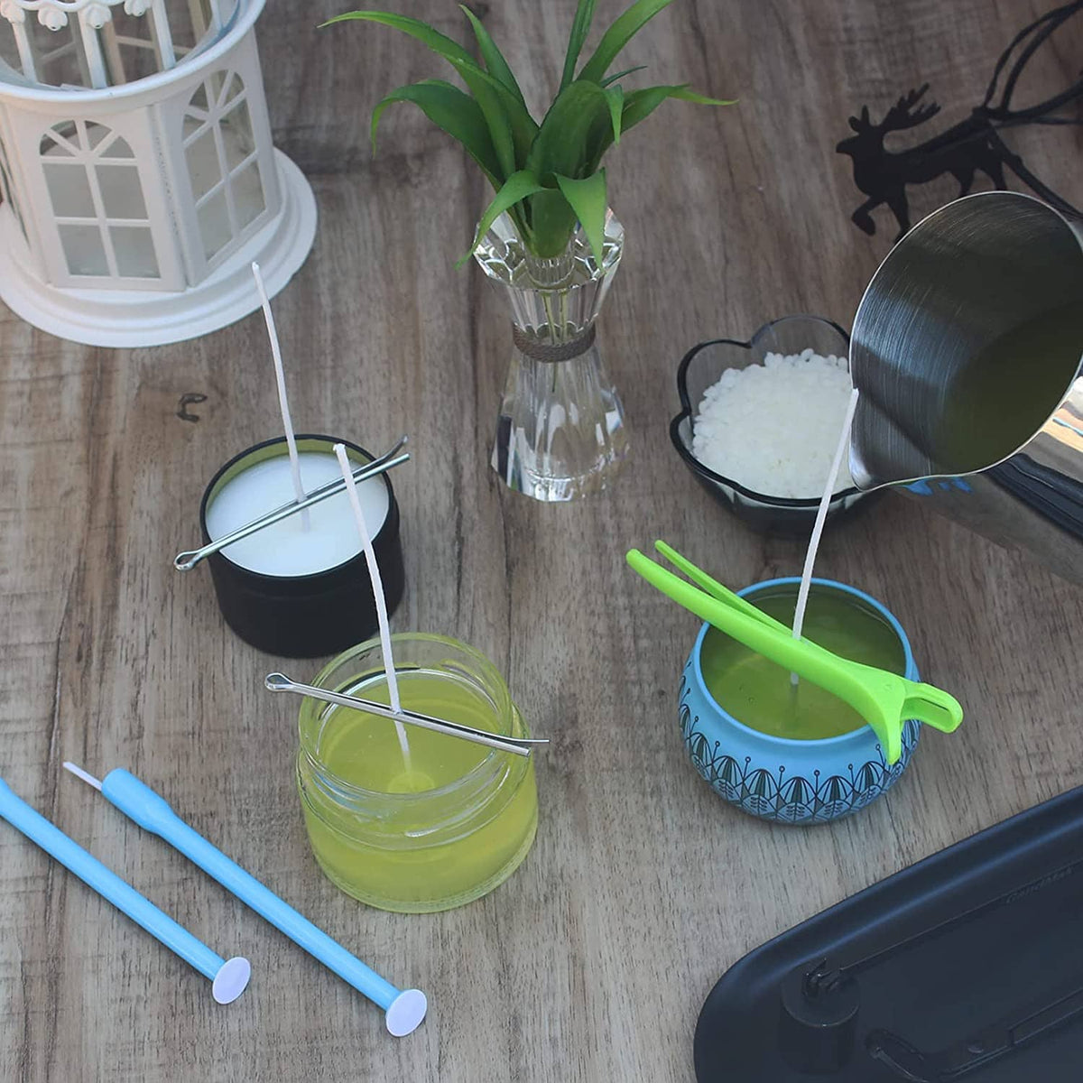 Candle wick kit with blue and green wick holders, wick placement tube, and cotton wicks in bowls