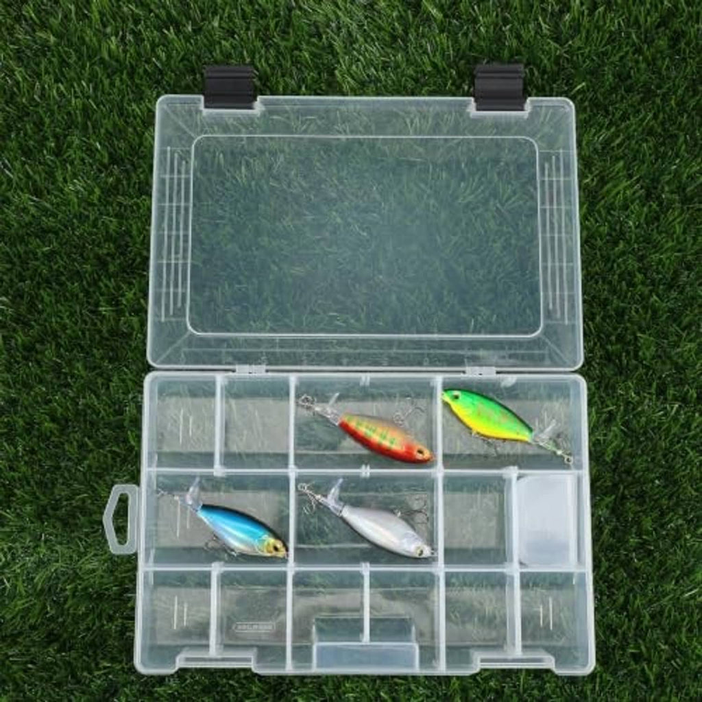 Clear tackle box on grass with lures stored across divided compartments