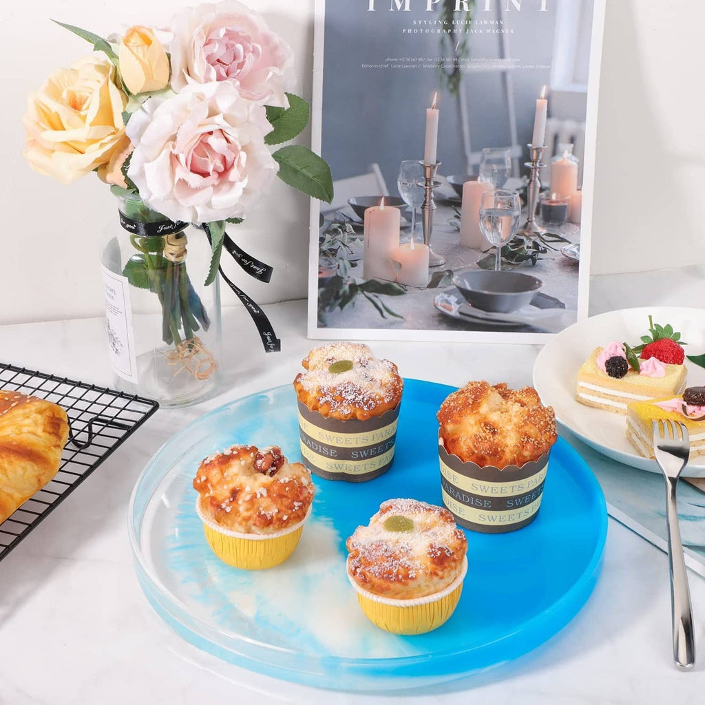 Large round resin serving tray mold with blue base holding cupcakes and candles