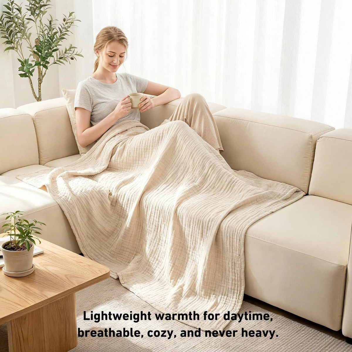 Cream cotton muslin blanket draped over a sofa, with lightweight layered fabric texture.