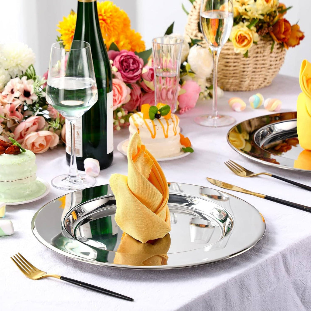 Round silver stainless steel charger plate with folded yellow napkin and cutlery